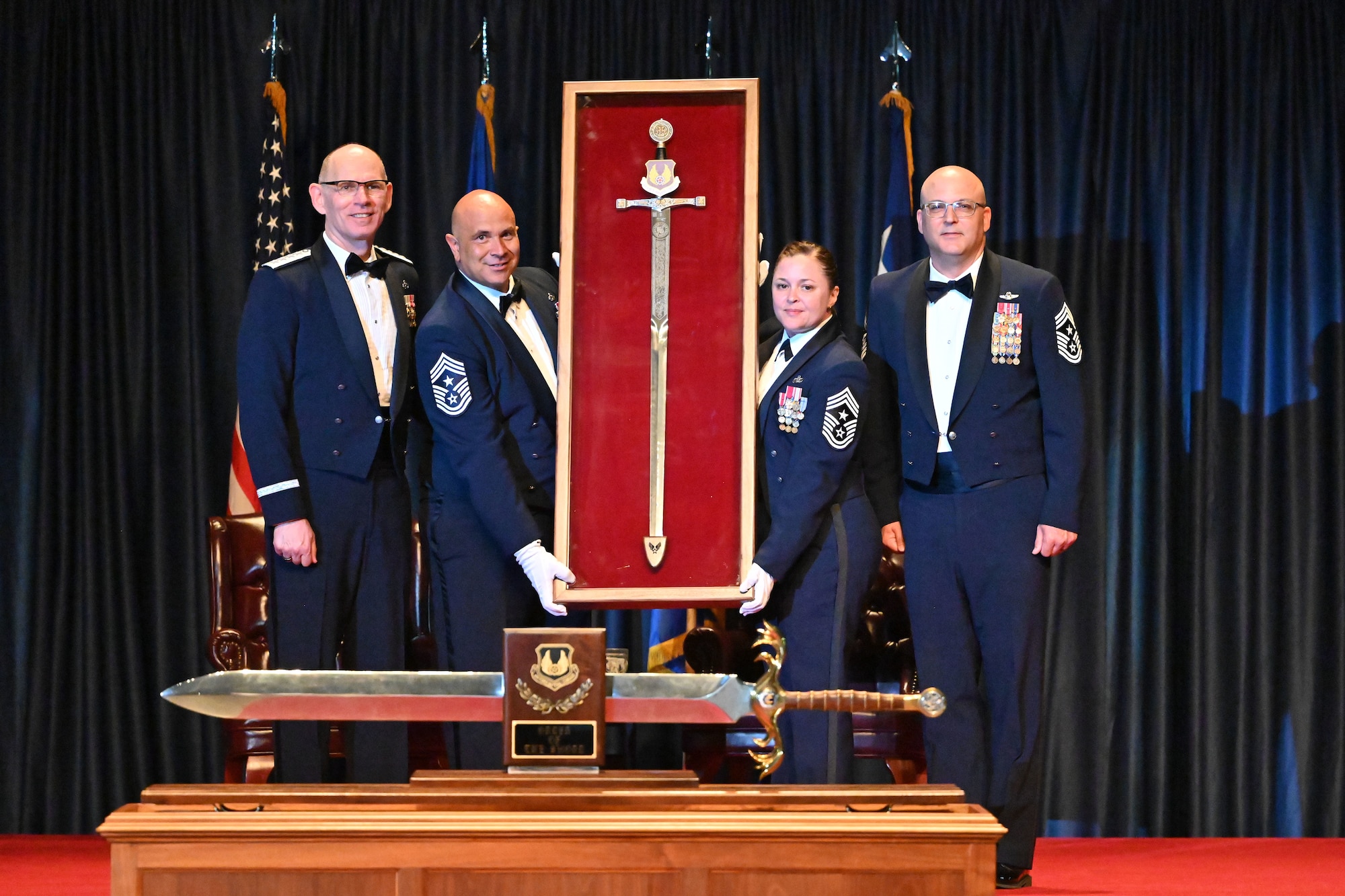 Gen. Duke Z. Richardson poses with Chief Master Sgt. Jalil Samavarchian, Chief Master Sgt. Tessa M. Fontaine, and Chief Master Sgt. Bill Fitch following the presentation of Richardson’s personal sword.