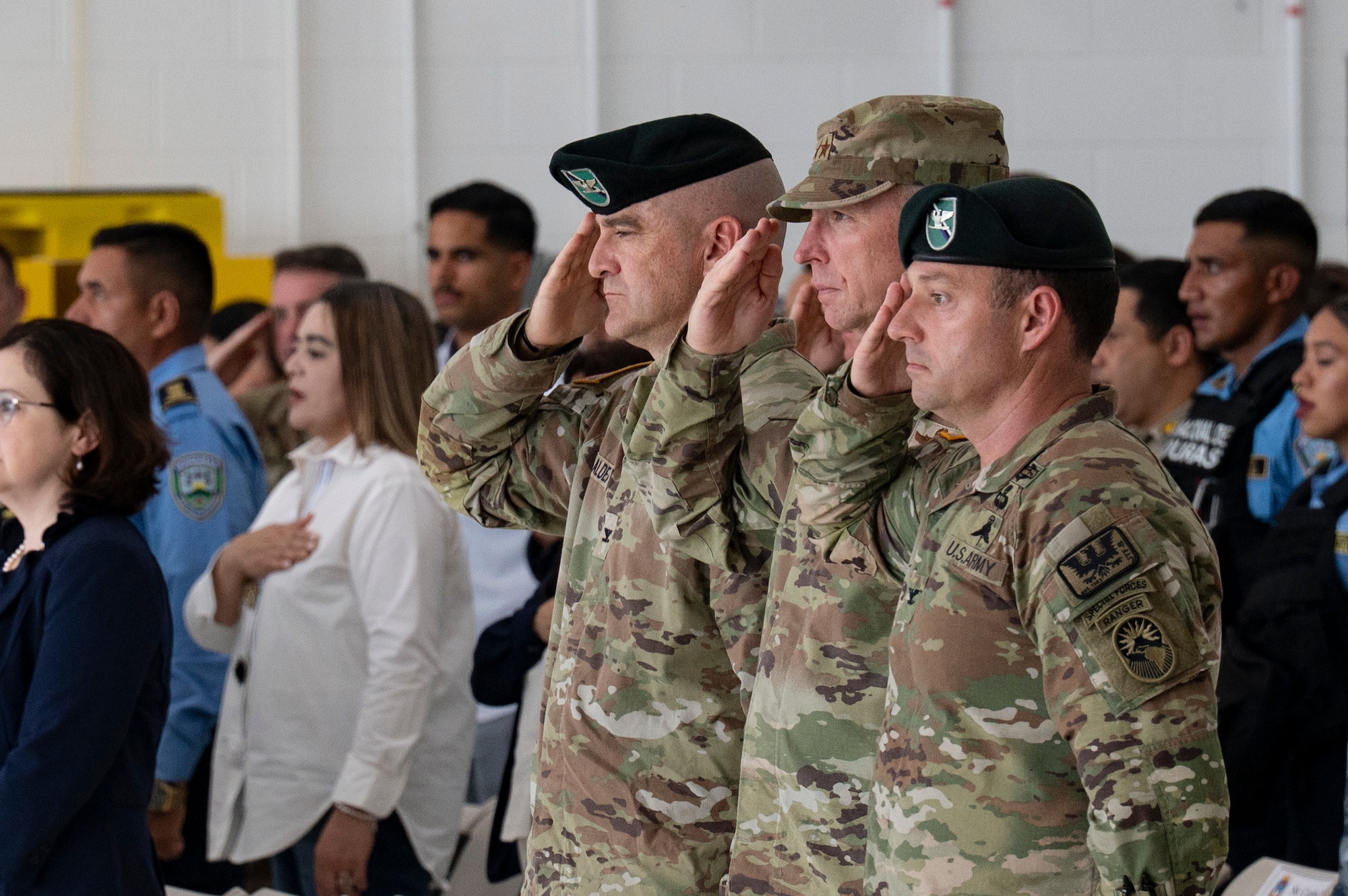 Joint Task Force Bravo change of command members render salutes during the playing of the service anthems.