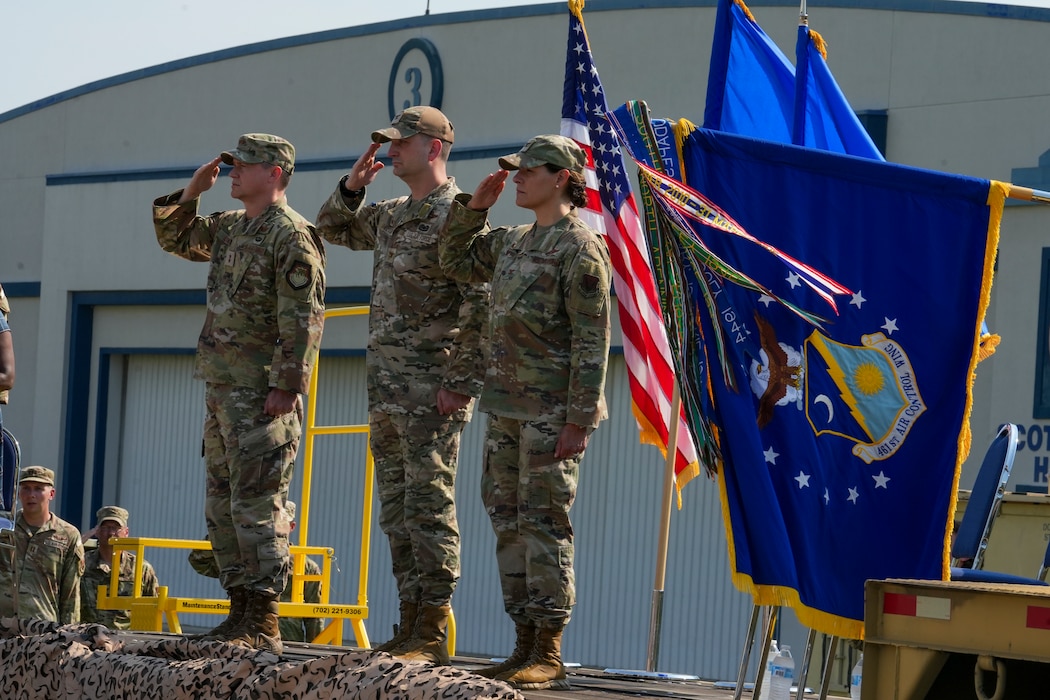 Three Air Force commanders salute on stage