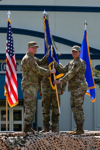 An Air Force commander passes a guidon to another commander