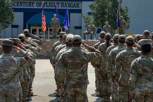 Airmen salute a commander on stage