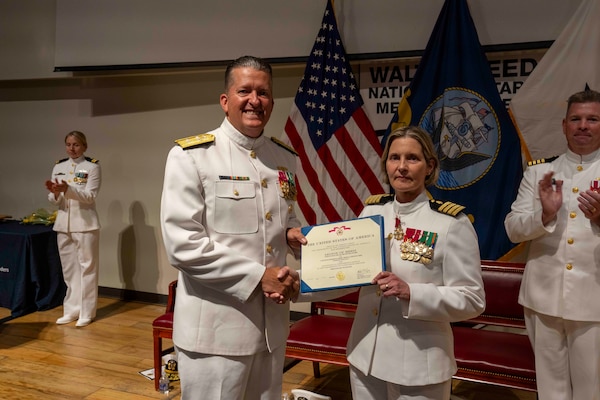 250616-N-JC800-1066 BETHESDA, Md. (June 12, 2025) - Rear Adm. Walter Bradford, Commander, Naval Forces Development Command, presents the Legion of Merit to Capt. Katarine Shobe, commanding officer of Naval Medical Leader and Professional Development Command, during the NMLPDC's Change of Command Ceremony, Jun. 12. (U.S. Navy photo by Mass Communication Specialist 1st Class Heath Zeigler/Released)
