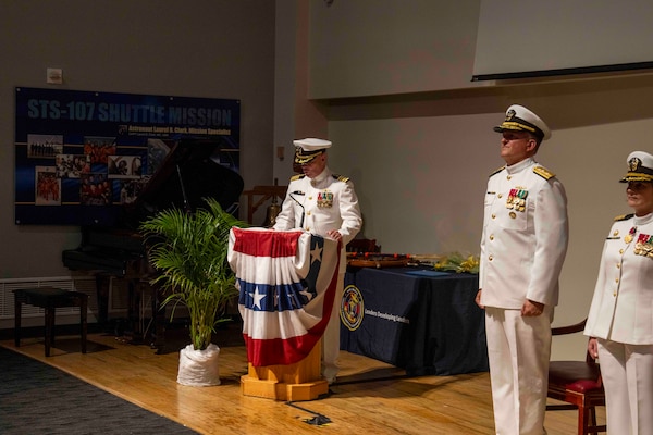 250616-N-JC800-1085 BETHESDA, Md. (June 12, 2025) - Capt. James Corbett, presumtive comanding officer of Naval Medical Leader and Professional Development Command, reads his orders during NMLPDC's Change of Command Ceremony, Jun. 12. (U.S. Navy photo by Mass Communication Specialist 1st Class Heath Zeigler/Released)