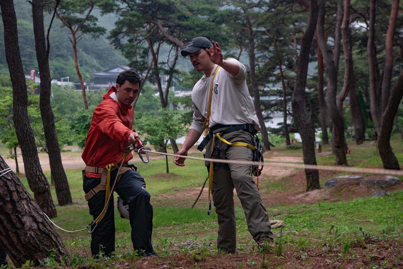 U.S. Army Staff Sgt. Elijah Moon, right, a mountaineer with the Defense POW/ MIA Accounting Agency, assists Midshipman 1st Class Nicholas Feaster, U.S. Naval Academy, on how to use an ascender as a part of mission training on a DPAA recovery mission in South Korea, May 22, 2025.