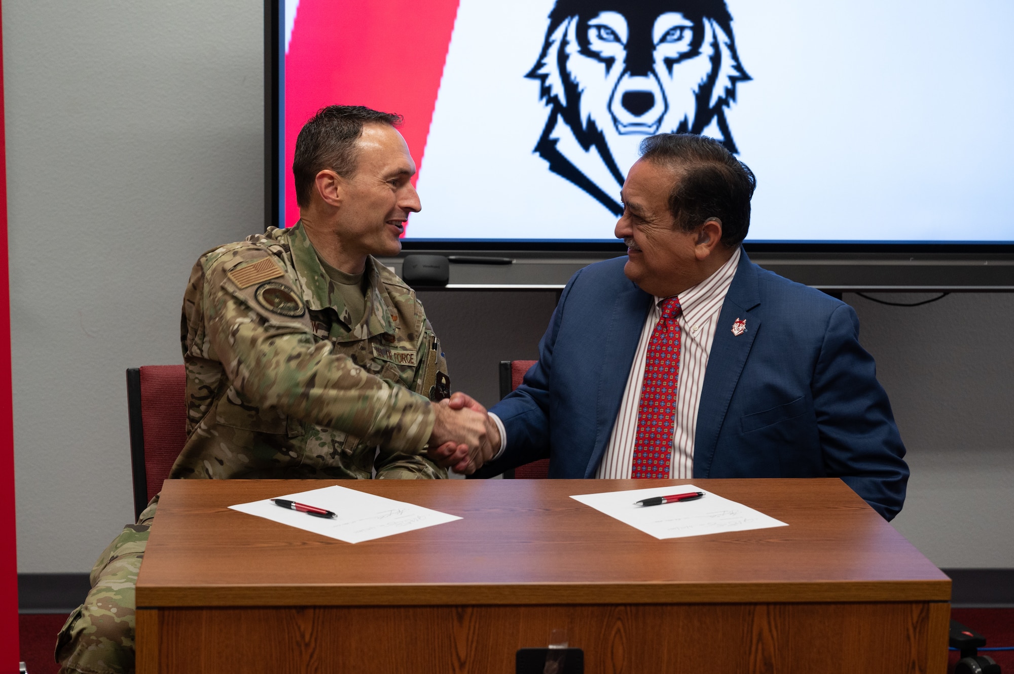 U.S. Air Force Col. Tyler Ellison, 47th Flying Training Wing commander, and Sul Ross State University President Carlos Hernandez shake hands following the signing of a partnership agreement in Del Rio, Texas, June 25, 2025. The event celebrated a joint commitment to empowering service members through accessible education. (U.S. Air Force photo by Joseph Pagan)