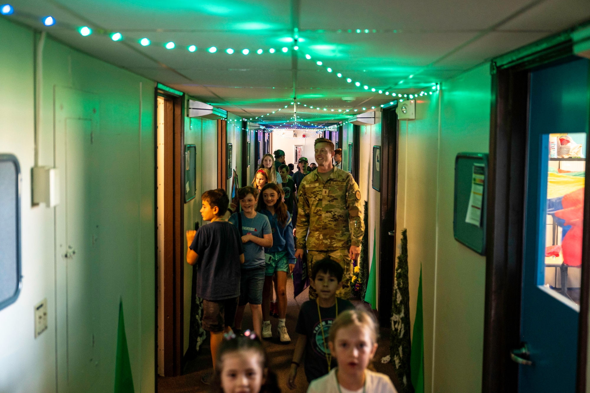 Children and adults walking through a hallway