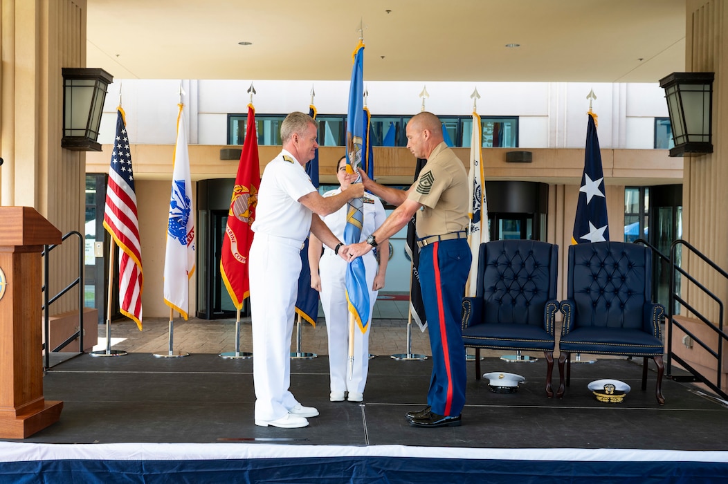 Adm. Samuel J. Paparo, commander of U.S. Indo-Pacific Command, passes the colors to U.S. Marine Corps Sgt. Maj. Eric Cook during Cook's Command Senior Enlisted Leader Assumption of Responsibility Ceremony at USINDOPACOM headquarters on Camp H.M. Smith, in Honolulu, June 26, 2025.