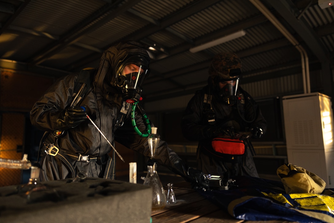 U.S. Marine Corps Cpl. Roen Algea, left, and Lance Cpl. Brady Badigian, both chemical, biological, radiological, and nuclear defense specialists with CBRN Response Element, 31st Marine Expeditionary Unit, conduct sensitive site assessment and exploitation training during a CRE exercise at Sam Hill Airfield, Queensland, Australia, June 20, 2025. The Marines conducted response in a simulated unknown hazardous environment to verify the extent of the hazard, identify the materials, and provide updates to protect the force. The 31st MEU is operating aboard ships of the USS America Amphibious Ready Group in the 7th Fleet area of operations, the U.S. Navy’s largest forward-deployed numbered fleet, and routinely interacts and operates with allies and partners in preserving a free and open Indo-Pacific region. Algea is a native of Georgia and Badigian is a native of Idaho. (U.S. Marine Corps photo by Cpl. Alora Finigan)