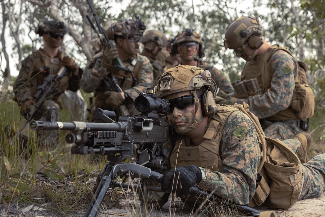 U.S. Marines with Animal Company, Battalion Landing Team 1st Battalion, 7th Marine Regiment, 31st Marine Expeditionary Unit, designate left and right lateral limits to establish interlocking fields of fire with adjacent machine gunners during a simulated raid at Shoal Water Bay training area, Queensland, Australia, June 21, 2025. The raid simulated employing Marines to rapidly capture and control objectives essential to operations. The 31st MEU is operating aboard the ships of the USS America Amphibious Ready Group in the 7th Fleet area of operations, the U.S. Navy’s largest forward deployed numbered fleet, and routinely interacts and operates with allies and partners in preserving a free and open Indo-Pacific region. (U.S. Marine Corps photo by Lance Cpl. Victor Gurrola)