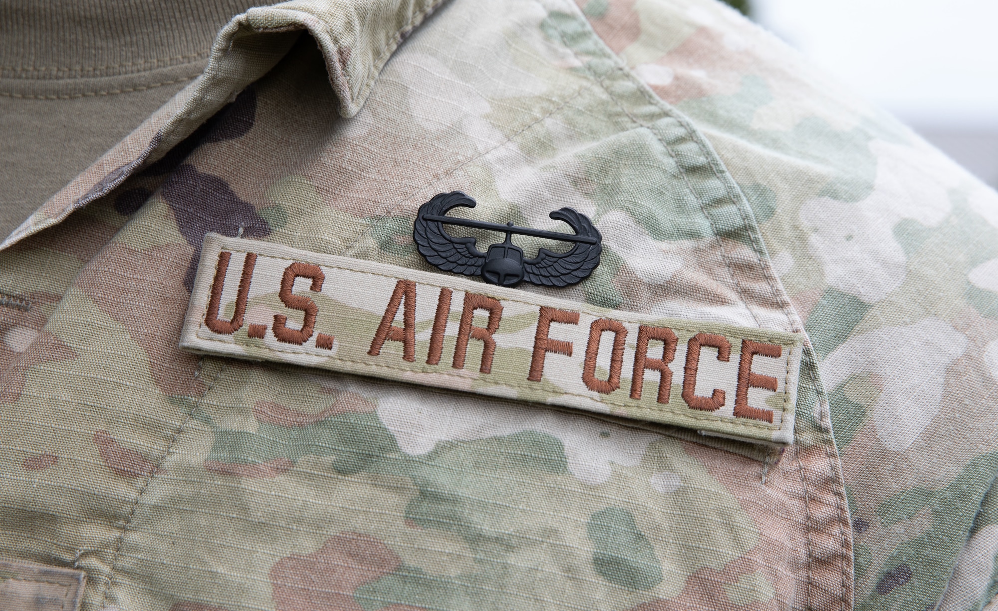 The Air Assault badge pinned on an Airman's chest above the U.S. Air Force nametape.