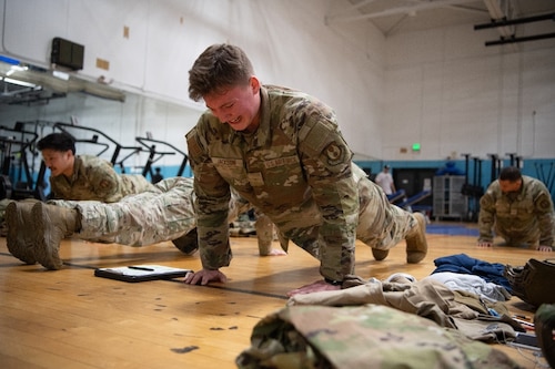 An Airman grimacing as he performs push-ups.
