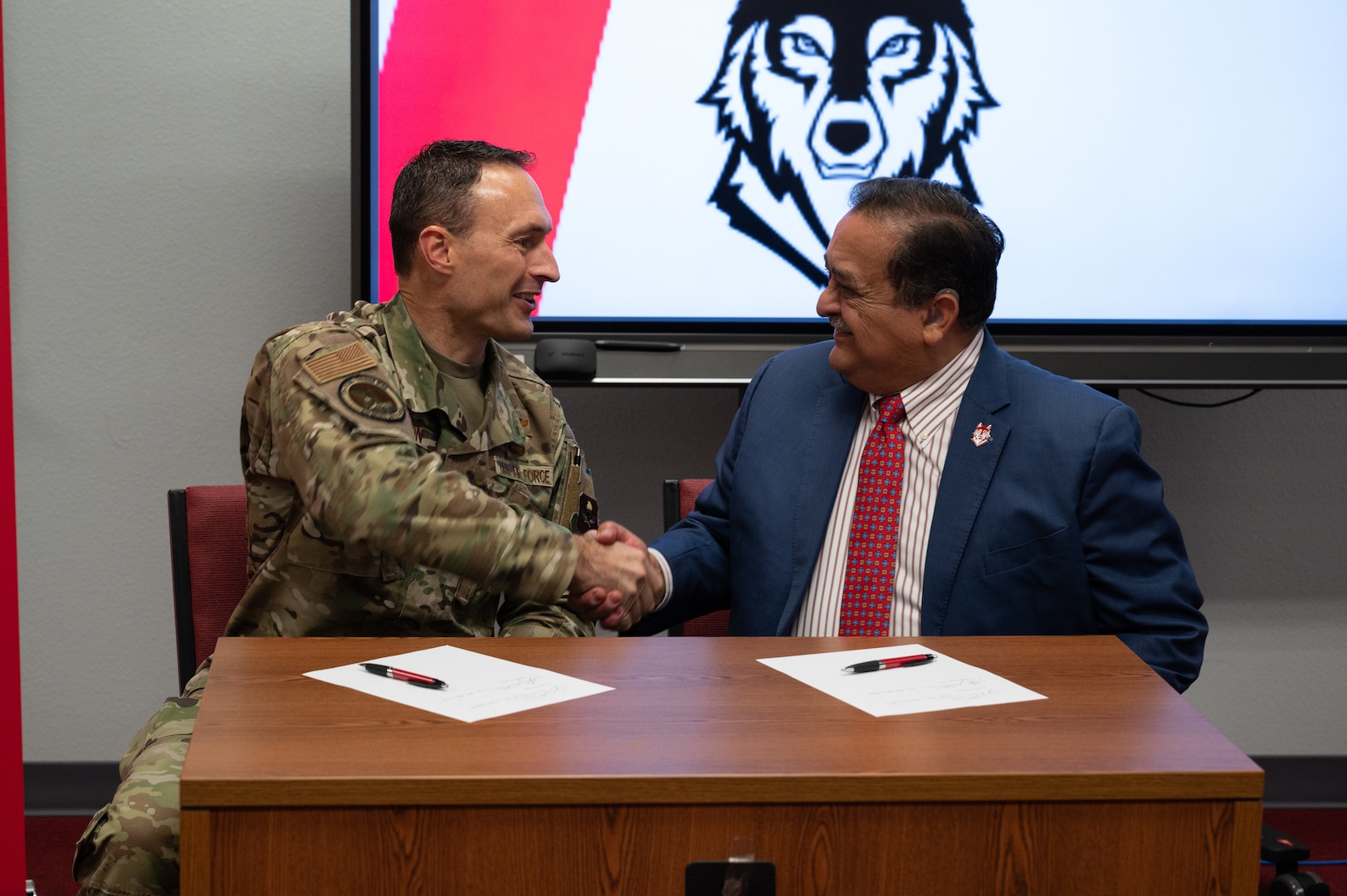 U.S. Air Force Col. Tyler Ellison, 47th Flying Training Wing commander, and Sul Ross State University President Carlos Hernandez shake hands following the signing of a partnership agreement in Del Rio, Texas, June 25, 2025. The event celebrated a joint commitment to empowering service members through accessible education. (U.S. Air Force photo by Joseph Pagan)