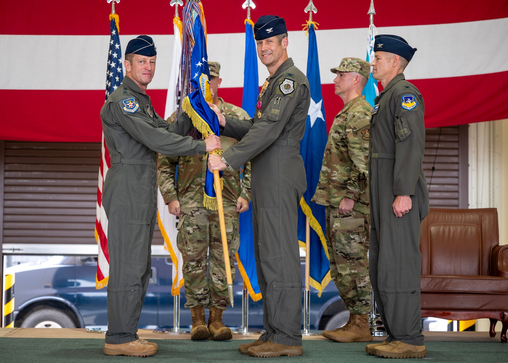 U.S. Air Force Col. William McKibban, center, outgoing 51st Fighter Wing commander, relinquishes command of the 51st FW to Lt. Gen. David Iverson, left, Seventh Air Force commander, during a Change of Command ceremony at Osan Air Base, Republic of Korea, June 27, 2025. Prior to assuming command of the 51st FW, McKibban served as the vice commander of the 52nd FW at Spangdahlem, Germany. (U.S. Air Force photo by Staff Sgt. Sarah Williams)