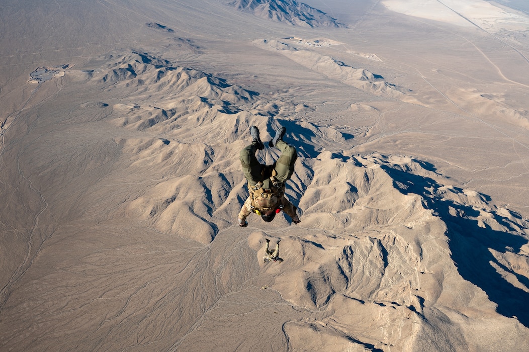 Airmen parachuting over a desert