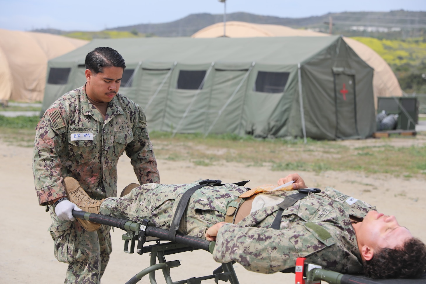 Hospital Apprentice Juan Casassanchez, moves Equipment Operator Constructionman Hayden Hernandez, a casualty role player, Naval Mobile Construction Battalion FIVE (NMCB-5), on a litter during training at Naval Expeditionary Medicine Warfighter Development Center (NEMWDC) May 3-16. (U.S. Navy photo by Petty Officer 2nd Class Kwame Obengyeboah)