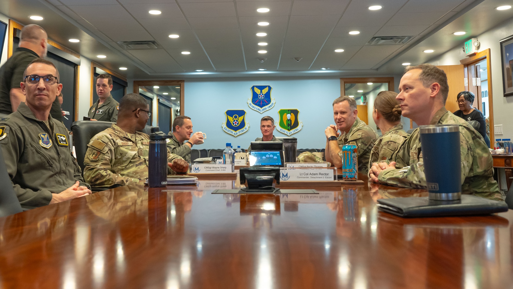 Airmen sit around a conference table for a briefing.
