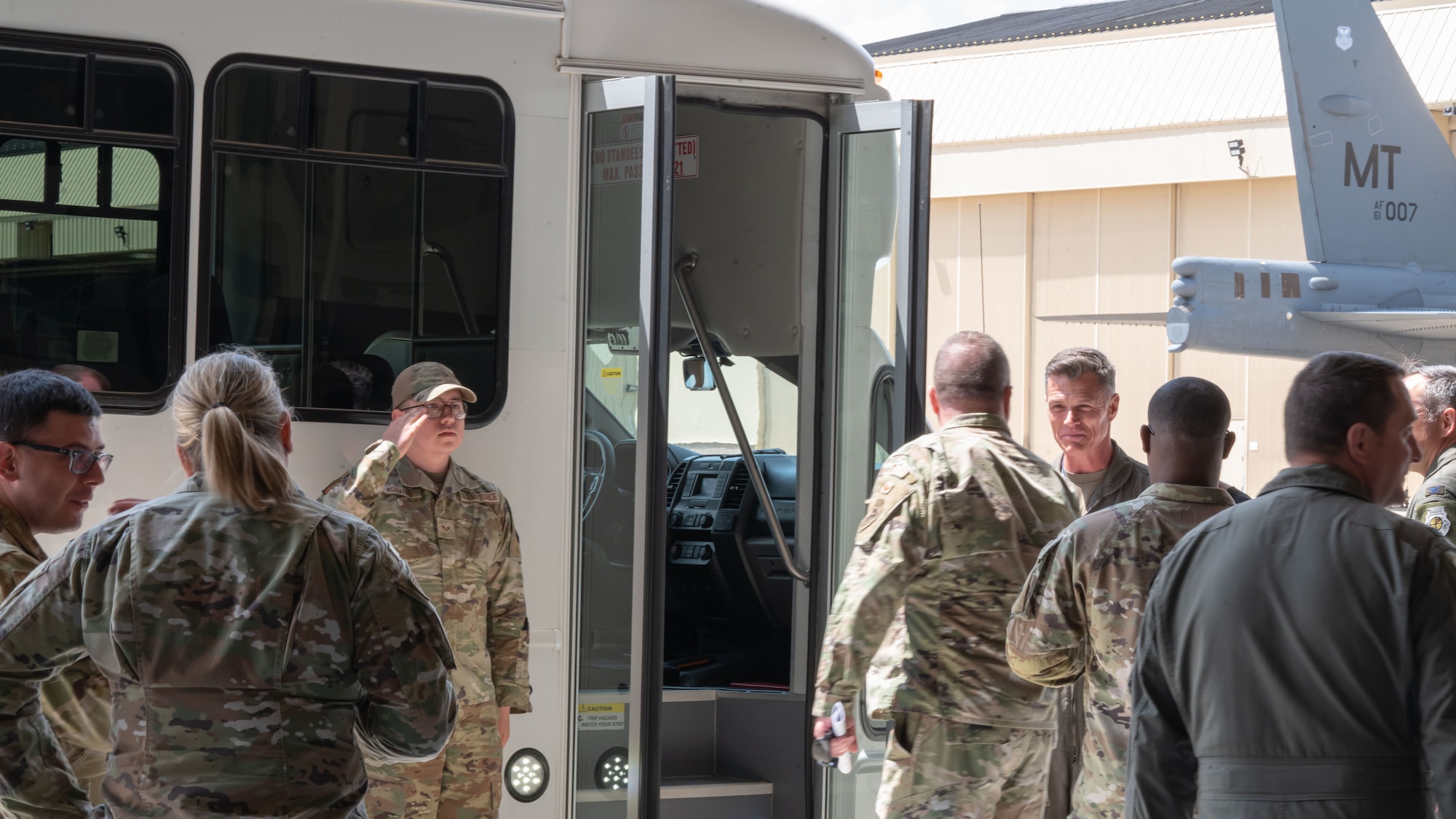 Airmen greet Maj. Gen. Michael Drowley as he gets out of a bus.
