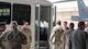 Airmen greet Maj. Gen. Michael Drowley as he gets out of a bus.