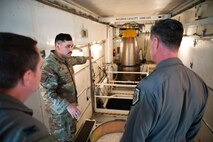 A missile maintenance team Airman shows around the interior of a payload transporter.