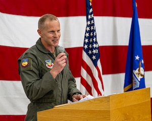 A photo of an officer at a podium during a change of command ceremony