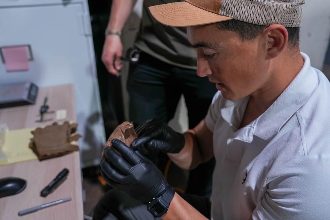 U.S. Marine Corps Staff Sgt. Radcliff Humphrey, an explosive ordnance disposal technician with Combat Logistics Battalion 8, Combat Logistics Regiment 2, 2nd Marine Logistics Group, inspects a piece of a cannon ball at the Smithsonian’s National Museum of American History, Washington, D.C., May 27, 2025. EOD Marines from 2nd MLG, II MEF, and 3rd MLG, collaborated with the Smithsonian’s National Museum of American History to provide subject matter expertise in the identification and verification of unique ordnance dating from the American Civil War to the Vietnam War. (U.S. Marine Corps photo by Lance Cpl. Javier Santillan)