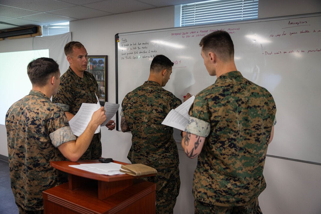 U.S. Marine Corps officers with 2d Marine Division, participate in a critical thinking exercise during Division Leads Assessment Program, on Marine Corps Base Camp Lejeune, North Carolina, June 19, 2025. The program consists of multiple events which assess future company commanders across 2d MARDIV. (U.S. Marine Corps photo illustration by Lance Cpl. Hunter J. Kuester)