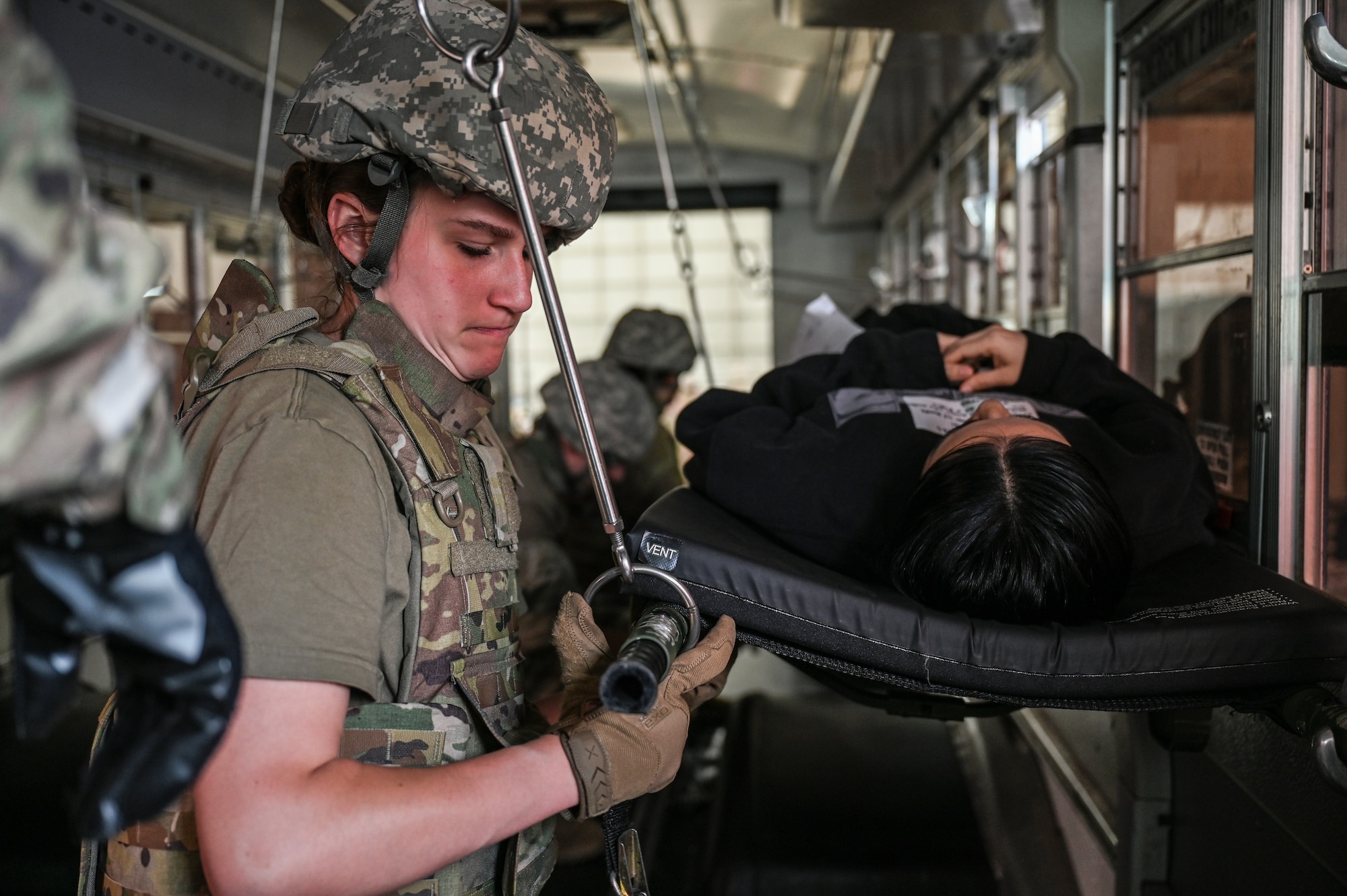 U.S. Air Force Staff Sgt. Haley Andrews, 445th Aeromedical Staging Squadron medical technician, secures a litter containing a simulated casualty on a medical bus during Exercise Relentless Valor at Wright-Patterson Air Force Base, Ohio, June 7, 2025. The exercise which included U.S. Army, U.S. Air Force, U.S. Navy and U.S. Marine Corps members was designed to enhance the joint force’s ability to maneuver and conduct missions in contested, degraded and operationally limited environments. (U.S. Air Force photo by Master Sgt. Patrick OReilly)