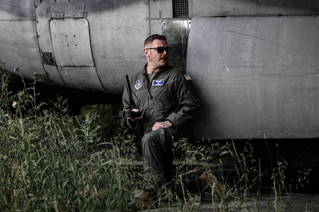 U.S. Air Force 1st Lt. Austin Schutte, 89th Airlift Squadron C-17 Globemaster III pilot, takes cover and utilizes a handheld radio during a Survival Evasion Resistance Escape (SERE) personnel recovery training at Wright-Patterson Air Force Base, Ohio, June 7, 2025. The training is used by pilots and crew members to maintain their knowledge should they become a downed pilot. (U.S. Air Force photo by Master Sgt. Patrick OReilly)