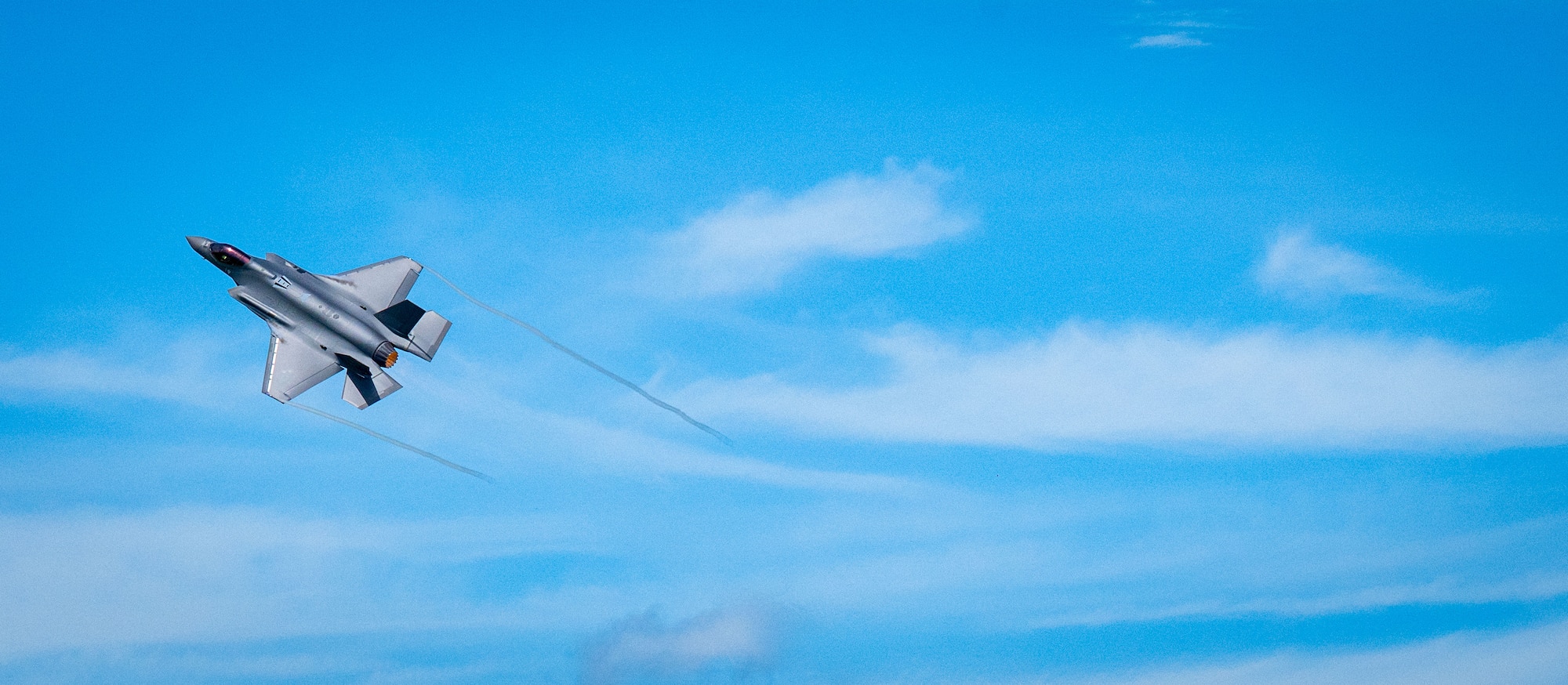 A U.S. Air Force F-35A Lightning II from the 187th Fighter Wing flies at low-level during a comprehensive noise exercise at Moody Air Force Base, Georgia, June 18, 2025. The assessment sought to determine the effectiveness of existing noise barriers around the airfield in mitigating the F-35A's sound emissions. (U.S. Air Force photo by 1st Lt. Benjamin Williams)