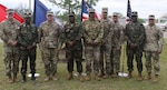 (From left) U.S. Army Col. Brian Martinus, Michigan National Guard State Chaplain; AFL Maj. Urias Zogaa, Chaplain General, Armed Forces of Liberia; U.S. Army Maj. Gen. Paul Rogers, Adjutant General, Michigan National Guard; AFL Maj. Gen. Davidson Forleh, Chief of Staff, Armed Forces of Liberia, U.S. Army Command Sgt. Maj. William Russell, III, Senior Enlisted Advisor, Michigan National Guard; U.S. Army Brig. Gen. Ravindra Wagh, Assistant Adjutant General, Michigan National Guard; CW5 Allen Robinson, State Command Warrant Officer, Michigan National Guard; AFL Lt. Col. Francis Gbodi, Military Advisor; Armed Forces of Liberia; U.S. Army Command Sgt. Maj. Matthew Hopkins, Senior Enlisted Advisor, Michigan Army National Guard, stand for a photo in front of a white pine – Michigan’s state tree – dedicated near the Camp Grayling chapel to symbolize the strength of the Michigan-Liberia partnership