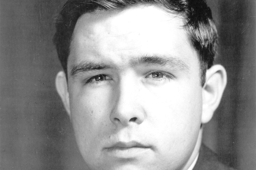 A man in a military dress uniform poses for a photo.
