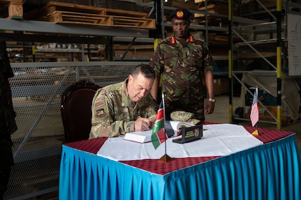 U.S. Air Force Maj. Gen. Gary Keefe, the adjutant general of the Massachusetts National Guard (MANG), signs a book beside Kenya Defence Forces (KDF) Lt. Gen. D K C Tarus, the commander of the Kenya Army, during his visit to the Kahawa Barracks in Nairobi, Kenya, May 30, 2025.