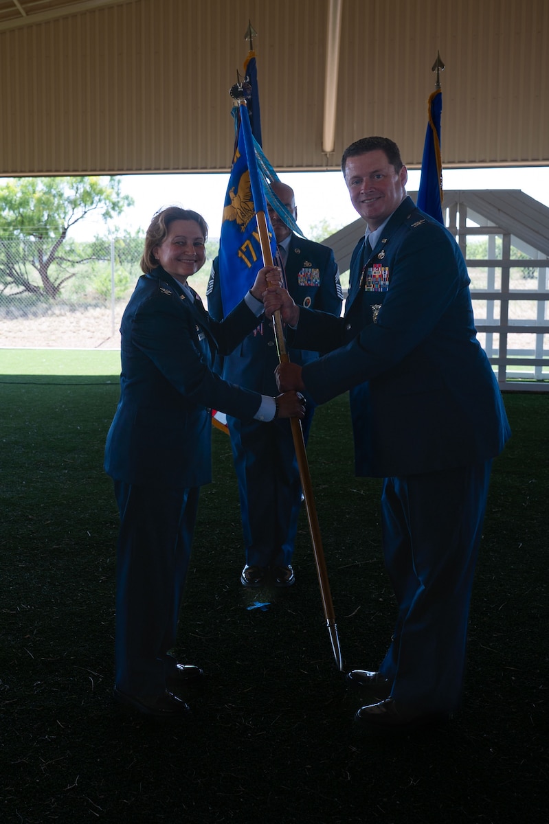 U.S. Air Force Col. Timothy Dalby, outgoing 17th Mission Support Group commander, passes the guidon to Col. Angelina Maguinness, 17th Training Wing commander, relinquishing command during the change of command ceremony at the 17th Security Forces Squadron kennels, Goodfellow Air Force Base, Texas, June 26, 2025. Passing the guidon represents the transfer of leadership responsibilities to the next commander. (U.S. Air Force photo by Airman 1st Class Brian Lummus)
