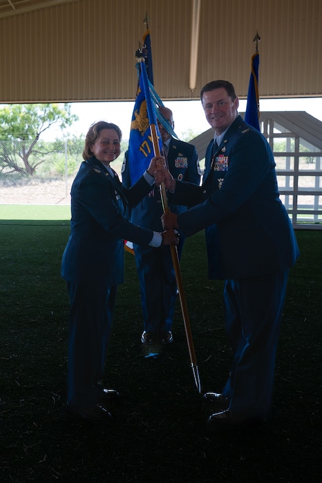 U.S. Air Force Col. Timothy Dalby, outgoing 17th Mission Support Group commander, passes the guidon to Col. Angelina Maguinness, 17th Training Wing commander, relinquishing command during the change of command ceremony at the 17th Security Forces Squadron kennels, Goodfellow Air Force Base, Texas, June 26, 2025. Passing the guidon represents the transfer of leadership responsibilities to the next commander. (U.S. Air Force photo by Airman 1st Class Brian Lummus)