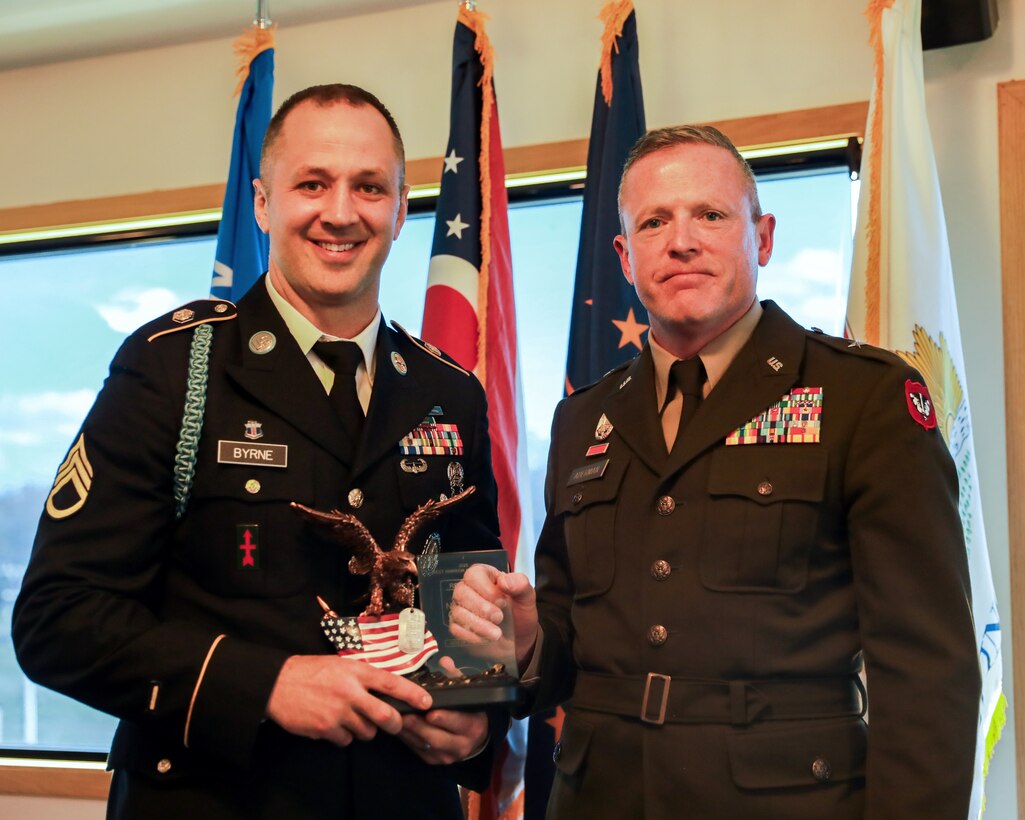 Wisconsin Army National Guard Staff Sgt. Brandon M. Byrne, a recruiting and retention noncommissioned officer with Alpha Company, Recruiting and Retention Battalion, is awarded Noncommissioned Officer of the Year by Brig. Gen. Brion J. Aderman, Wisconsin's deputy adjutant general for Army, during the closing ceremony of the National Guard Region IV Best Warrior Competition at Fort McCoy, Wis., May 3, 2025. The National Guard Region IV Best Warrior Competition is an annual event where the state best warriors from Illinois, Indiana, Iowa, Michigan, Minnesota, Ohio, and Wisconsin compete in various warrior skill challenges, with the selected winners advancing to the national competition. (U.S. Army National Guard photo by Spc. Emily Held)