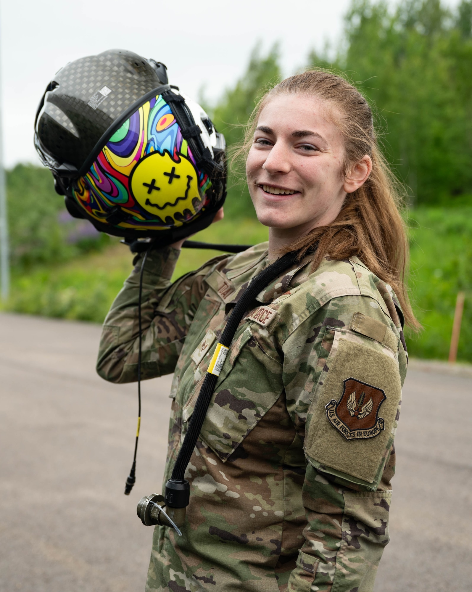 U.S. Air Force Senior Airman Lacy Toal, 495th Fighter Squadron lead aircrew flight equipment technician, poses for a photo with a pilot helmet during Atlantic Trident 25 at Pirkkala Air Base, Finland, June 26, 2025. Toal was responsible for coordinating, packing and transporting each participating aircrew member’s gear during AT 25, ensuring each pilot’s readiness for daily training sorties. (U.S. Air Force photo by Airman 1st Class Sierra Casteel)