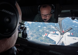 man looks at aircraft in flight from window of aircraft