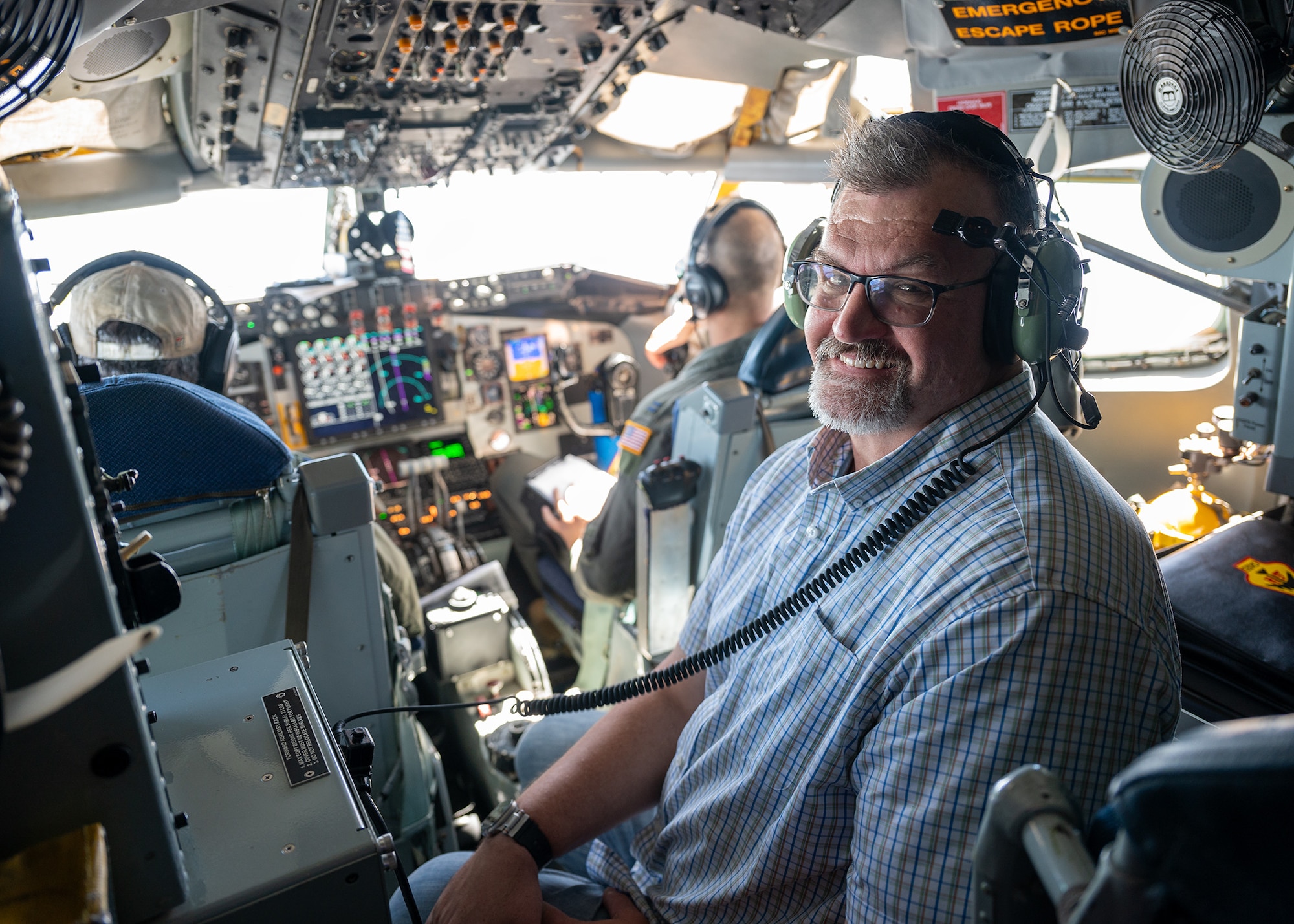 man poses for photo in cockpit of aircraft