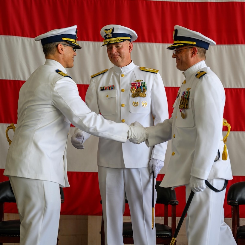 Capt. Aaron Ortenzio accepts the responsibilities of commanding officer of U.S. Coast Guard Air Station Miami from Capt. Eric Smith during a change of command ceremony at Air Station Miami, June 27, 2025. Rear Adm. Douglas Schofield, Seventh Coast Guard District commander, presided over the ceremony. (U.S. Coast Guard photo by Auxiliarist Joey Feldman)