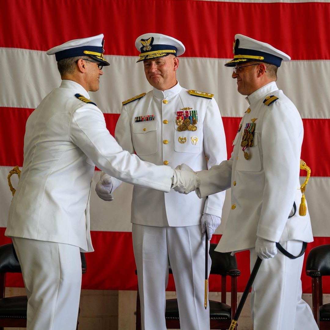Capt. Aaron Ortenzio accepts the responsibilities of commanding officer of U.S. Coast Guard Air Station Miami from Capt. Eric Smith during a change of command ceremony at Air Station Miami, June 27, 2025. Rear Adm. Douglas Schofield, Seventh Coast Guard District commander, presided over the ceremony. (U.S. Coast Guard photo by Auxiliarist Joey Feldman)