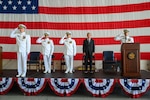 Rear Adm. Douglas Schofield (left), Seventh Coast Guard District commander, Capt. Eric Smith (second from left), former Air Station Miami commander, and Capt. Aaron Ortenzio (middle), Air Station Miami commander, render a salute during a change of command ceremony at Coast Guard Air Station Miami, June 27, 2025. During the ceremony Schofield presided as Ortenzio relieved Smith as the commander of Air Station Miami. (U.S. Coast Guard photo by Auxiliarist Joey Feldman)