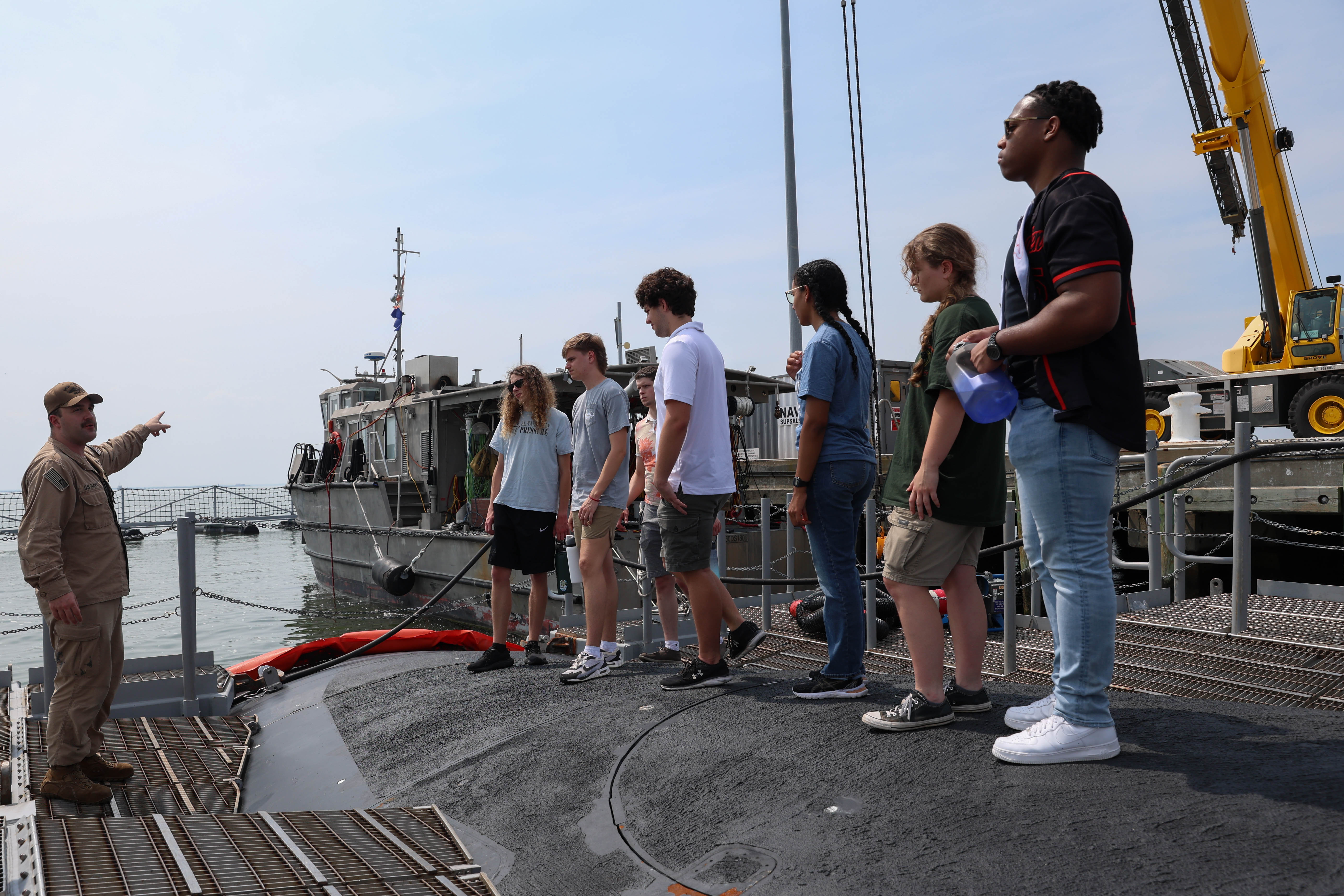 College students listen to a Submariner explain the different functions of the vessel during a tour of USS Oregon.