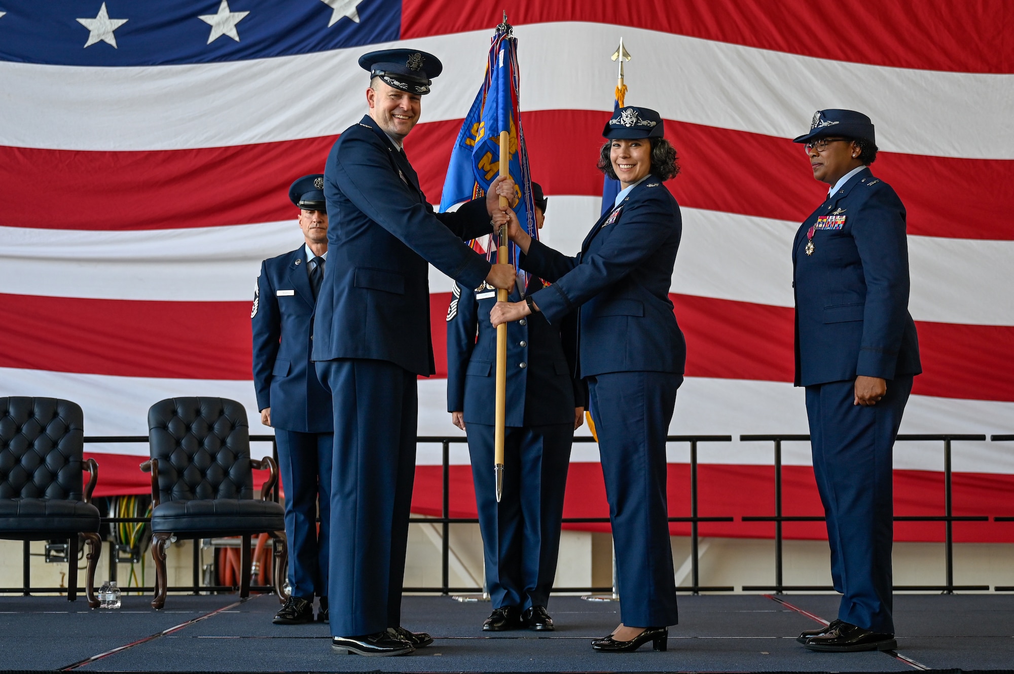 U.S. Air Force Col. Denny Davies (left), 19th Airlift Wing and installation commander, passes the guidon to Col. Katrina Smith, 19th Mission Support Group incoming commander, during a change of command ceremony, June 27, 2025, at Little Rock Air Force Base, Arkansas.