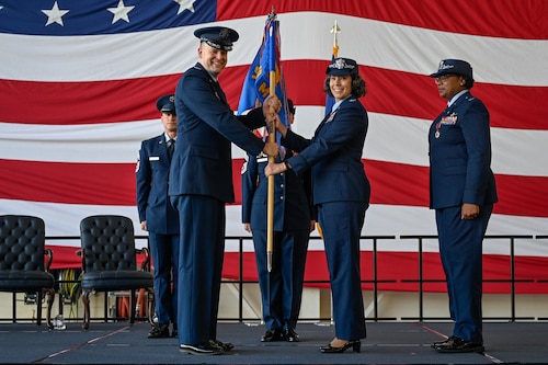 U.S. Air Force Col. Denny Davies (left), 19th Airlift Wing and installation commander, passes the guidon to Col. Katrina Smith, 19th Mission Support Group incoming commander, during a change of command ceremony, June 27, 2025, at Little Rock Air Force Base, Arkansas.