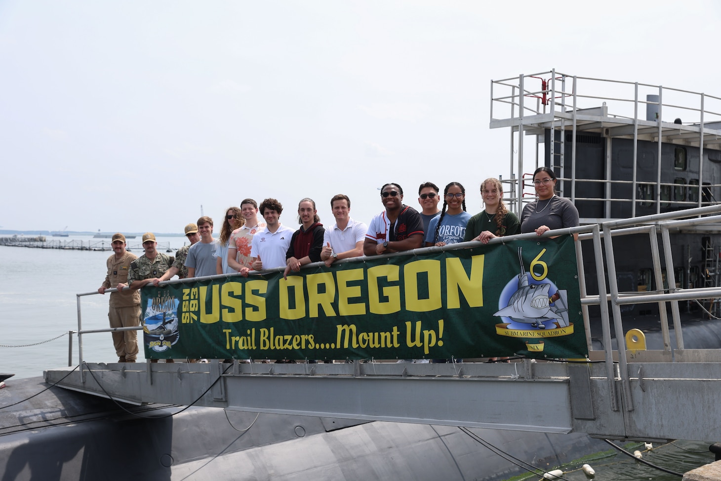 College student pose for a photo on the brow of USS Oregon