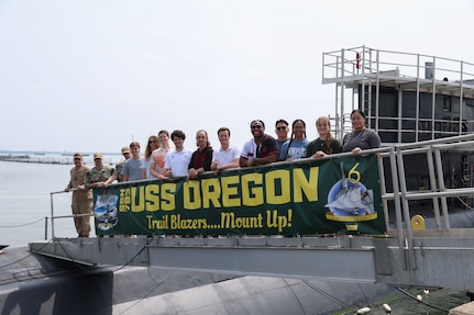 College student pose for a photo on the brow of USS Oregon