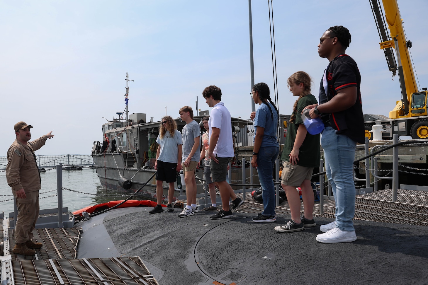 College students listen to a Submariner explain the different functions of the vessel during a tour of USS Oregon.