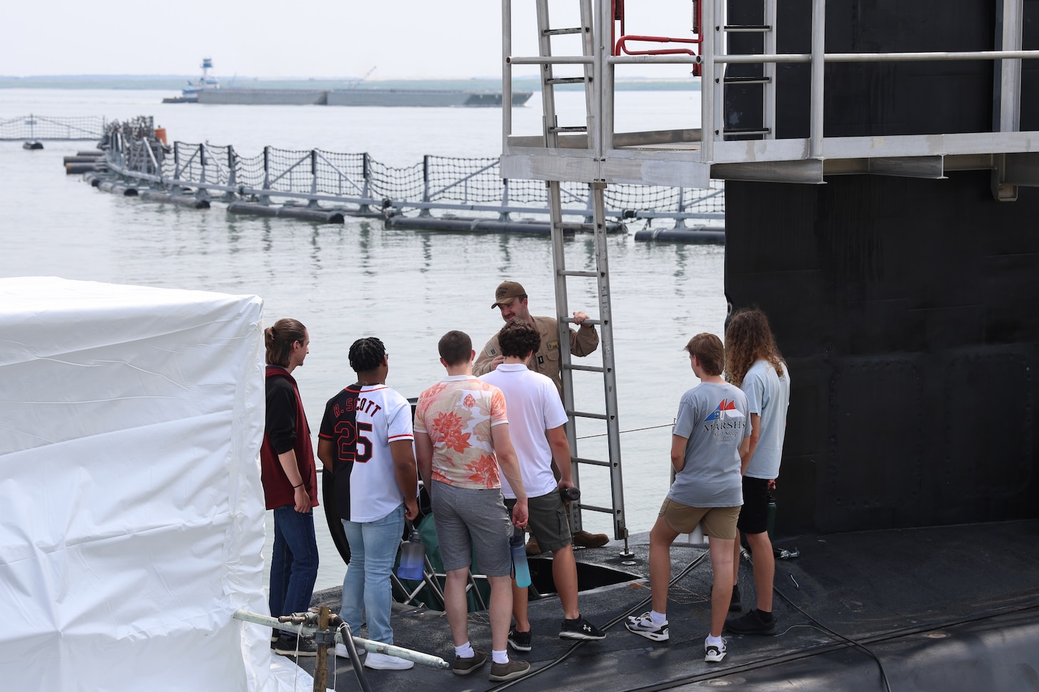 College students listen to a Submariner explain the different functions of the vessel during a tour of USS Oregon.