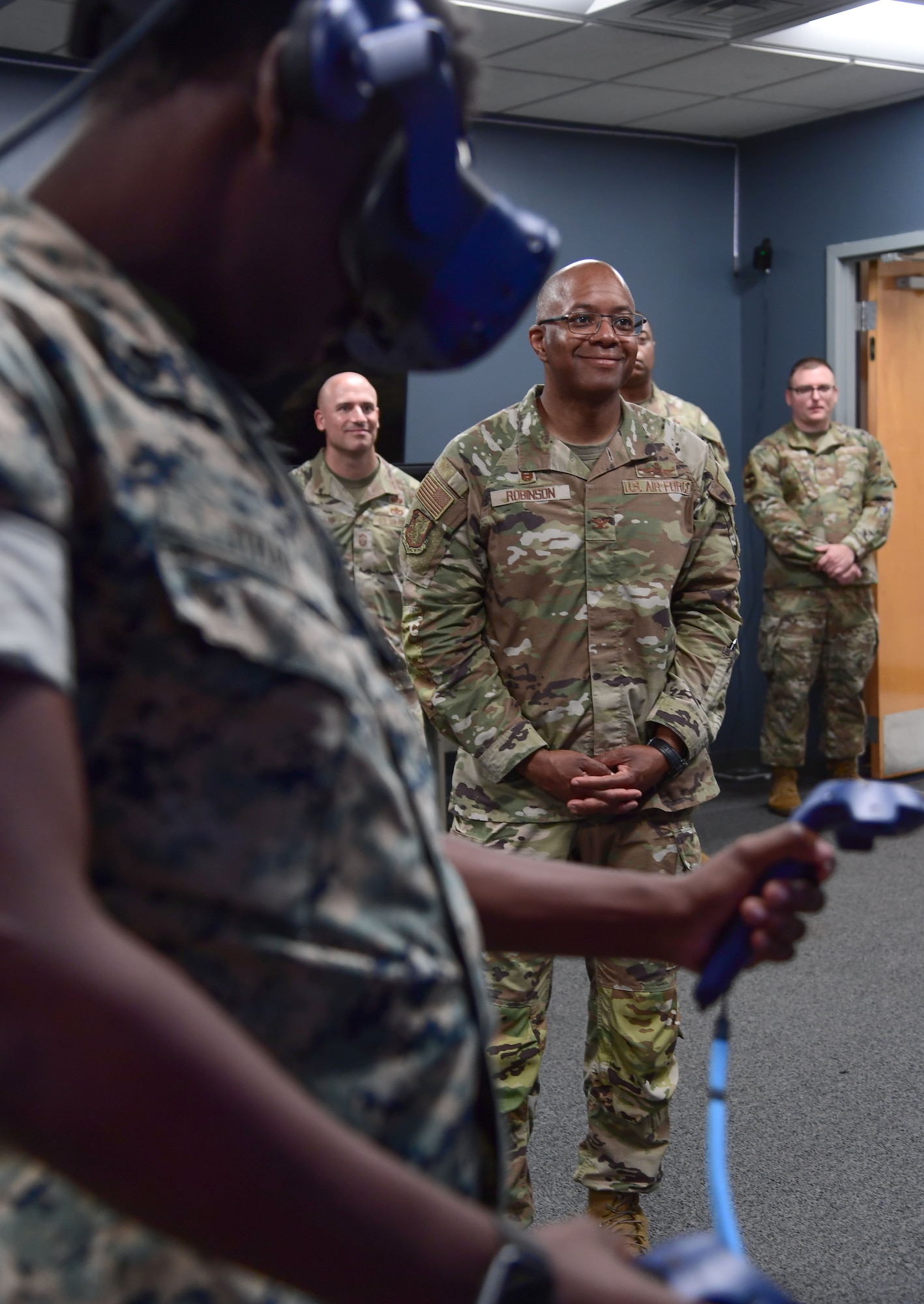 A man in military uniform watches a virtual reality demonstration.