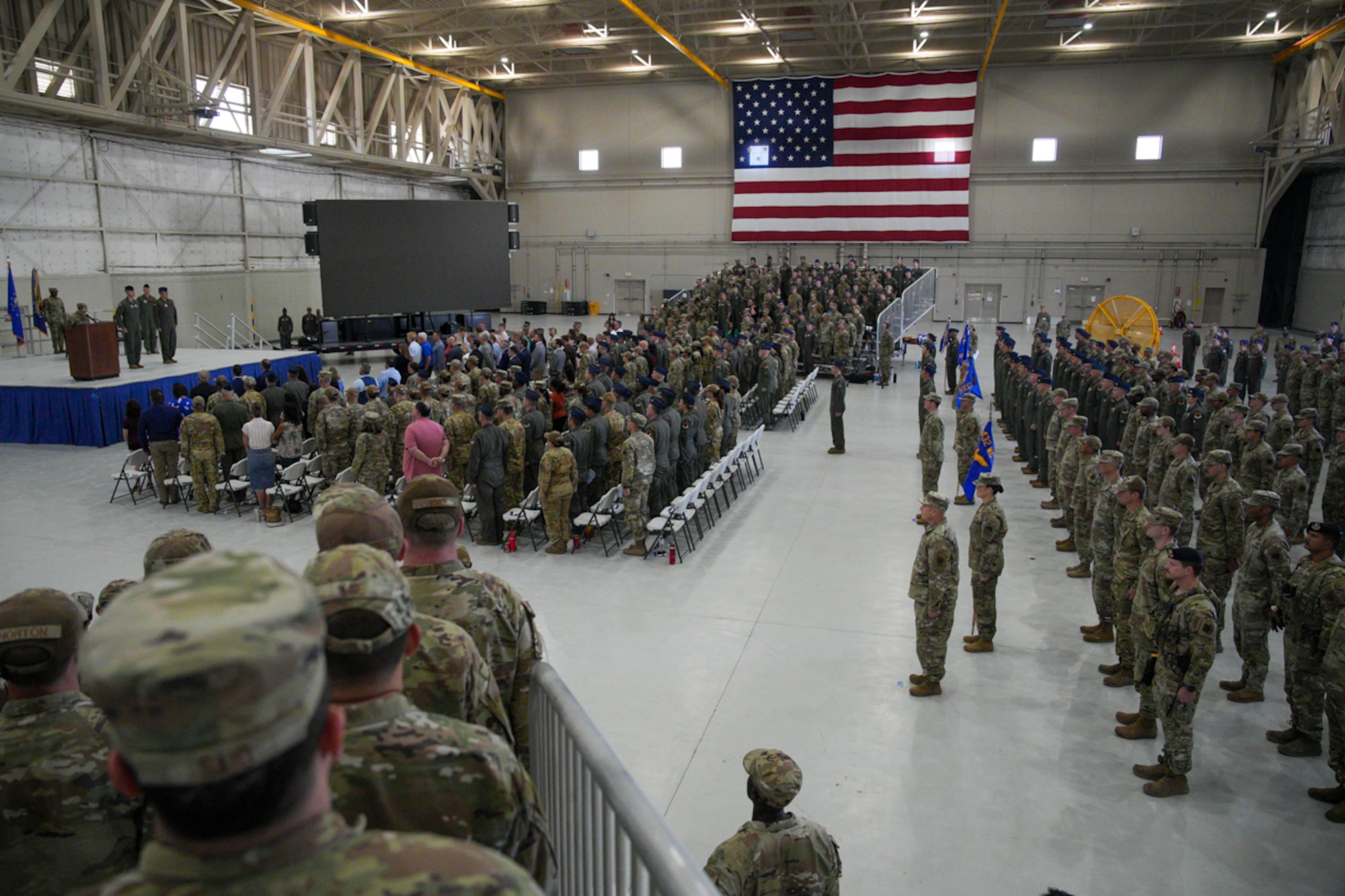 People in military uniforms stand at attention.